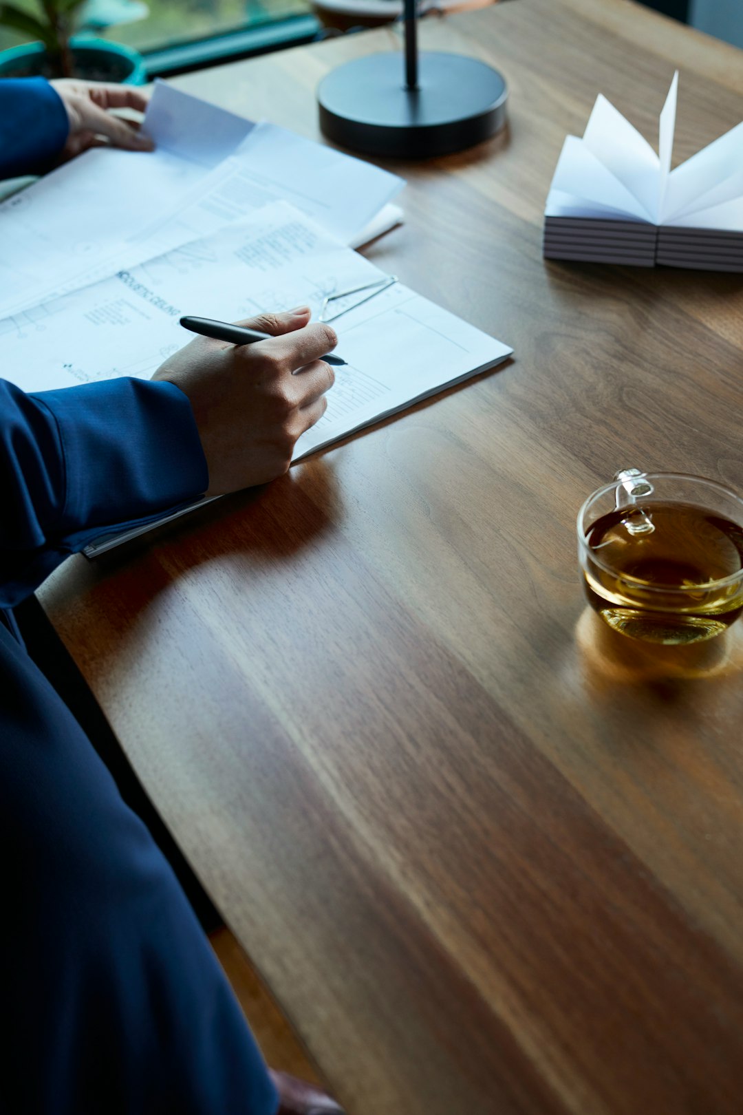 services-09 a-person-sitting-at-a-table-writing-on-a-piece-of-paper-e5bg-qjkpd8