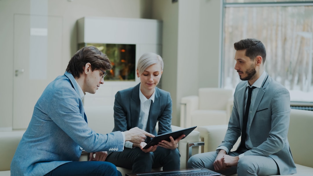 about-03 Panning shot of businessman discussing financial reports with female and male business partners sitting on sofa in modern office hall with indoors